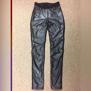 Stylish women's tight faux leather pants with zippers.